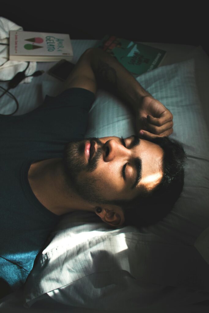 pexels-photo-3981599-3981599 A serene portrait of a young man sleeping peacefully in a sunlit bedroom setting.